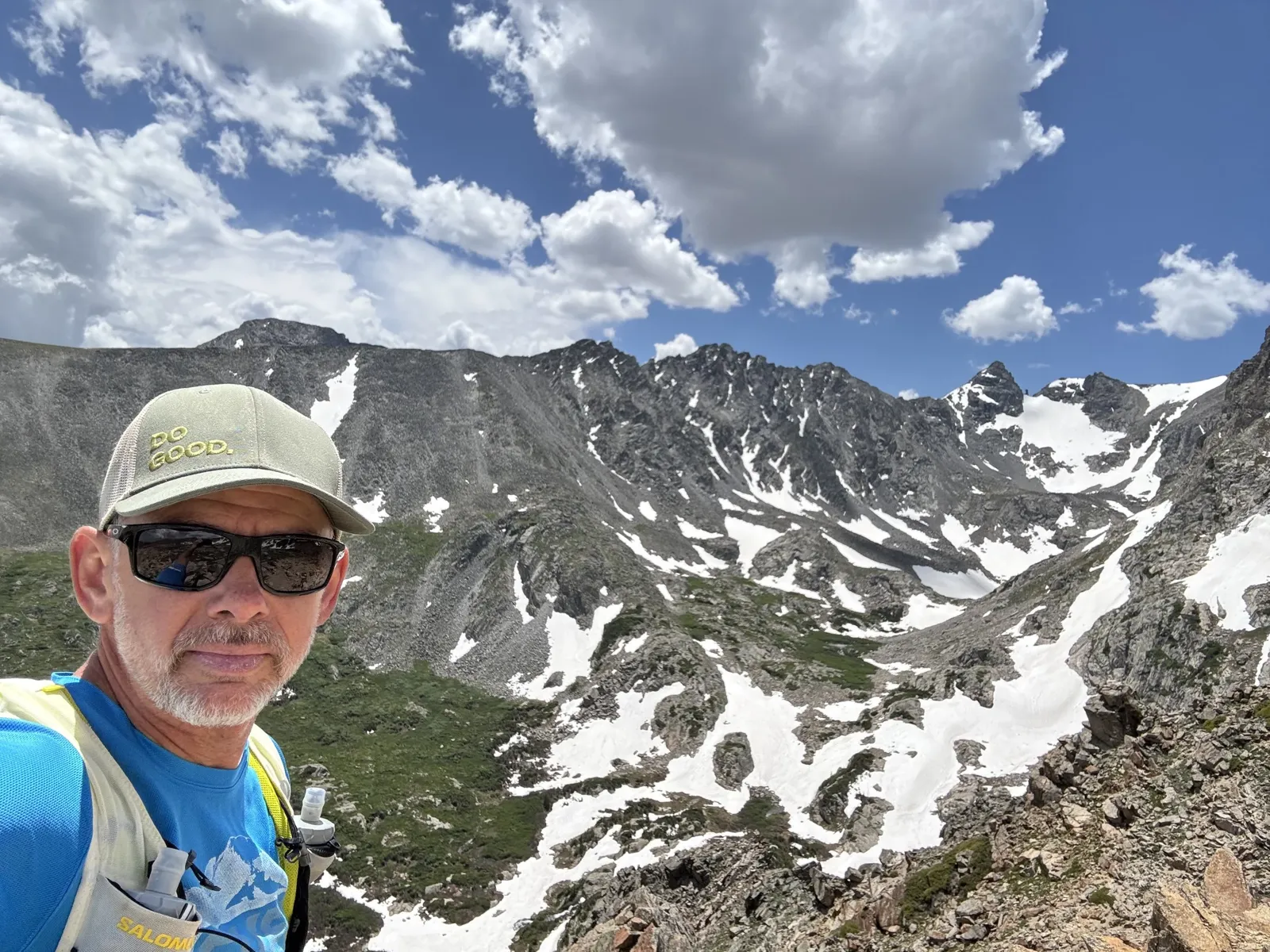 Scott Burd hiking in the Colorado mountains among snow-covered peaks